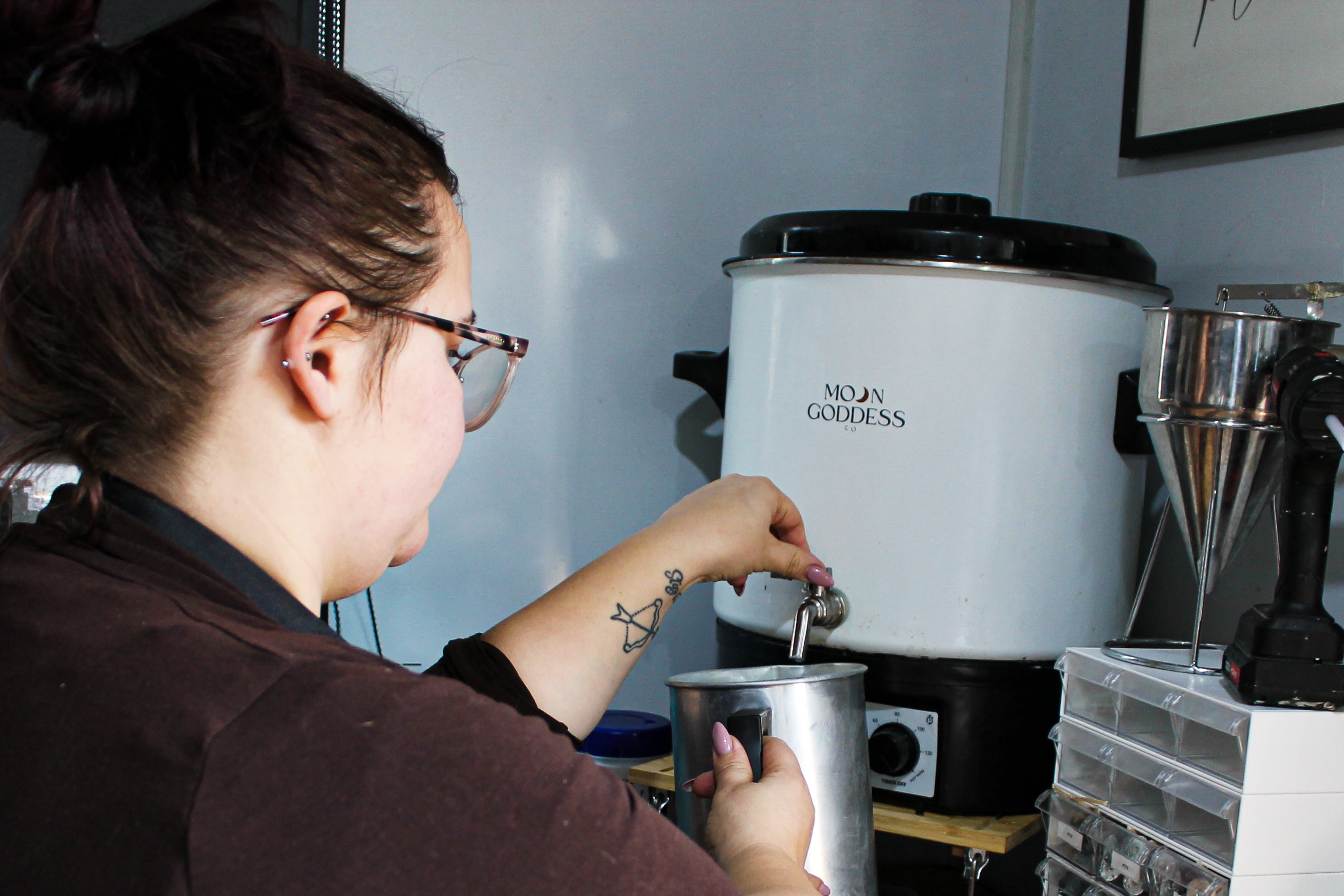 Founder Hayley operating a Moon Goddess wax pot in candle workshop